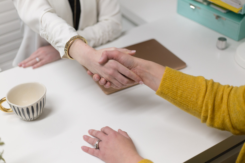 Handdruk aan tafel na een gesprek